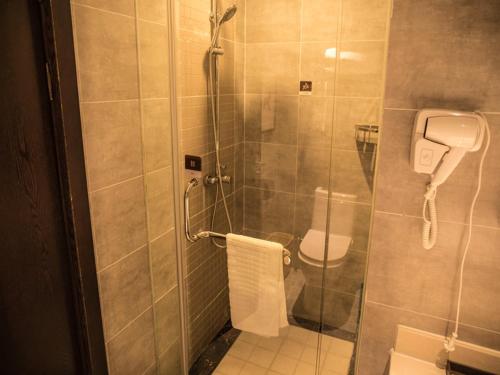 a bathroom with a toilet and a glass shower at JUN Hotels Yunnan Kunming Wuhua District Changyuan Middle Road in Kunming