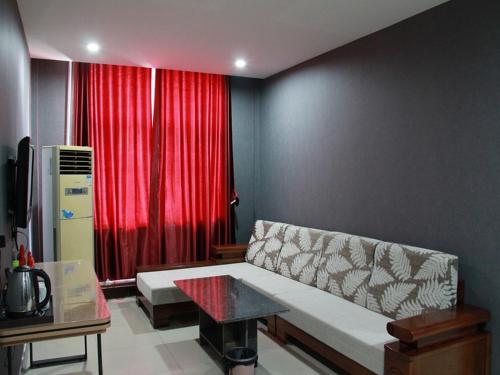 a living room with a couch and a red curtain at JUN Hotels Laiwu Laicheng District Changshao North Road in Laiwu