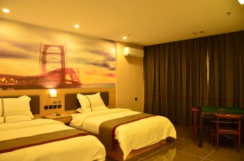 Fuzhou的住宿－尚客优酒店江西抚州临川区东华理工大学店，酒店客房设有两张床,墙上挂有绘画作品