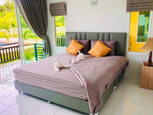 two stuffed animals sitting on a bed in a bedroom at Koh Chang Havana Pool Villa in Trat