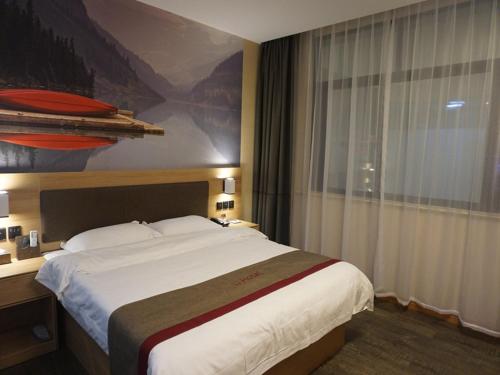 a hotel room with a large bed and a window at Thank Inn Chain Hotel Jinhua Dongyang City Nanma Town Chaoyang Road in Jinhua