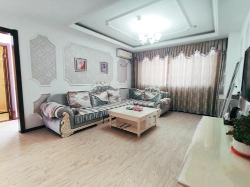 - un salon avec un canapé et une table basse dans l'établissement JUN Hotels Inner Mongolia Tongliao Hexi Chuangye Avenue, à Tongliao