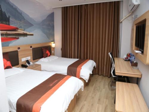 a hotel room with two beds and a desk at JUN Hotels Anhui Bangbu Guzhen County Huihe Road Store in Qiaokou