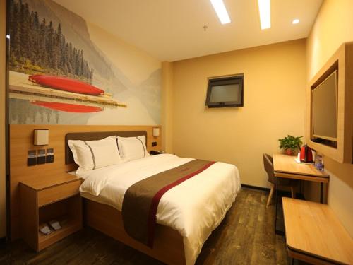 a bedroom with a bed and a desk and a television at Thank Inn Plus Hotel Shijiazhuang Gaocheng District Century Avenue in Shijiazhuang