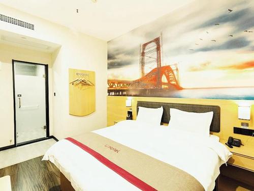 a bedroom with a large bed with a painting on the wall at Thank Inn Chain Hotel Xi'an Weiyang District High Speed Rail North Passenger Station in Xi'an