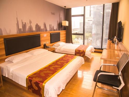 una habitación de hotel con 2 camas y una silla en Thank Inn Chain Hotel He'nan Zhengzhou Zhengdong New District East Staiton, en Zhengzhou