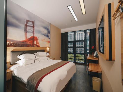 a bedroom with a large bed with a painting on the wall at Thank Inn Chain Hotel Yancheng Tinghu District Changting Commercial building in Yancheng