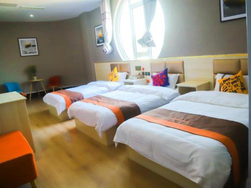 a room with three beds and a window at JUN Hotels Shandong Ji'nan Zhangqiu Diao Town Chemical Industrial Park 