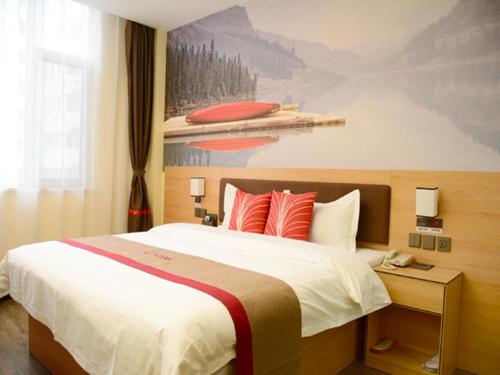 una habitación de hotel con una cama grande con almohadas rojas en Thank Inn Chain Hotel Shanxi Taiyuan Xiaodian District Zhenwu Road, en Taiyuán