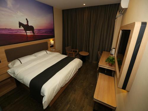 una habitación de hotel con una cama y una pintura de un camello en Thank Inn Chain Hotel Shanxi Xinzhou Xinfu District Xuefu East Street Heping Square en Xinzhou