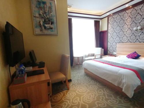 JianyangにあるJUN Hotels Sichuan Chengdu Jianyang Jiancheng Town Jianshe Roadのベッドとテレビが備わるホテルルームです。