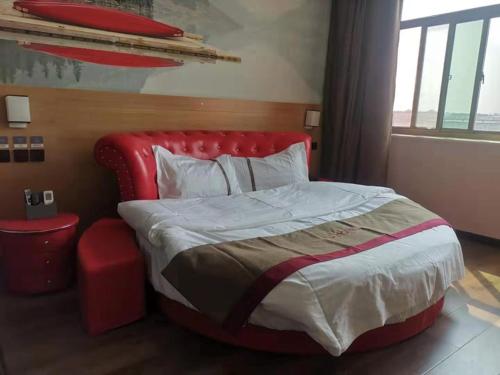 a bedroom with a large bed with a red headboard at Thank Inn Chain Hotel Hebei Hengshui Zaoqiang County Daying Town West Asia Fur Shop in Hengshui