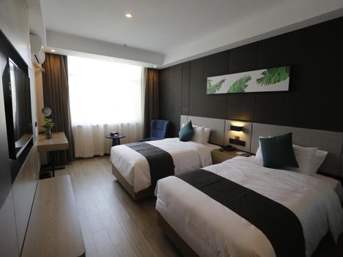 um quarto de hotel com duas camas e uma janela em Up and In Kashgar Xiyu Avenue Food Street em Kashgar