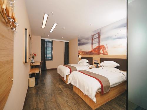 a hotel room with two beds and a desk at Thank Inn Chain Hotel Yancheng Tinghu District Changting Commercial building in Yancheng