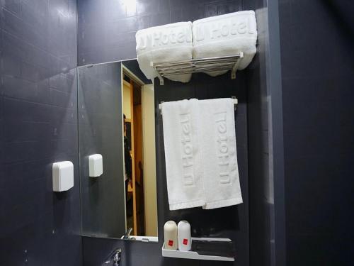 La salle de bains est pourvue d'un miroir et de serviettes blanches. dans l'établissement Thank Inn Plus Hotel Handan Wei County Xianbiao, à Handan
