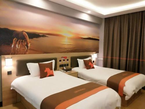 a hotel room with two beds and a painting on the wall at JUN Hotels Shandong Zaohuang Tengzhou Jinghe West Road in Tengzhou