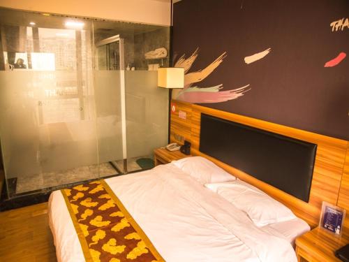 1 dormitorio con 1 cama con cabecero de madera en Thank Inn Chain Hotel He'nan Zhengzhou Zhengdong New District East Staiton, en Zhengzhou