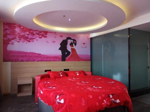 ein Schlafzimmer mit einem roten Bett mit einem Gemälde an der Wand in der Unterkunft Thank Inn Chain Hotel Shandong Ji'nan Jiyang Yingcai Academy (North) 