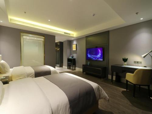 a hotel room with two beds and a flat screen tv at Lano Hotel Kashgar Shache County Youyi West Road in Shache