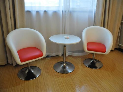 two chairs and a table in a room at JUN Hotels Henan Luoyang Xigong District Central Bus Station in Luoyang