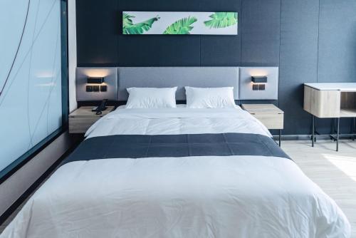 een slaapkamer met een groot wit bed in een kamer bij Up And In Qingdao Jimo District Aoshanwei Blue Silicon Valley in Qingdao