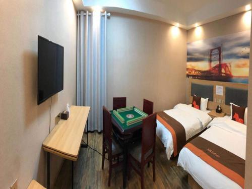 Habitación de hotel con 2 camas, escritorio y TV. en JUN Hotels Hunan Zhuzhou Shifeng District Qingshi Plaza en Zhuzhou