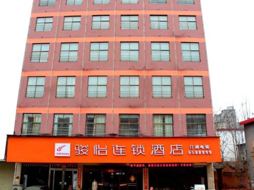 周口的住宿－骏怡连锁河南周口沈丘兆丰大道店，一座红色的大建筑,上面写着中国文字