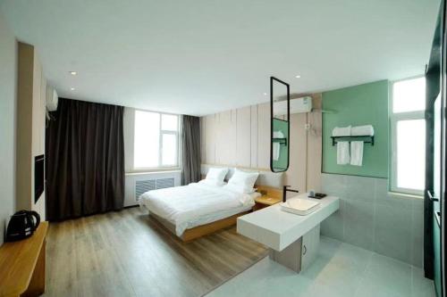 1 dormitorio con cama y escritorio. en JUN Hotels Shanxi Taiyuan Gaoxin Community en Taiyuán