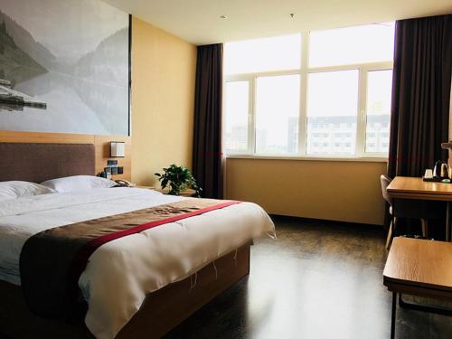 a hotel room with a bed and a desk and window at Thank Inn Chain Hotel Hebei Baoding Jingxiu District Lugang International in Baoding