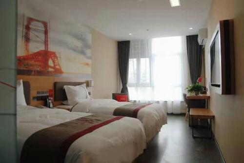 ein Hotelzimmer mit 3 Betten und einem Fenster in der Unterkunft Thank Inn Chain Hotel Tianjing Jingnan District Balitai Town Industrial Park in Tianjin