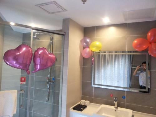 uma pessoa tirando uma foto de uma casa de banho com balões em Up And In Jiangsu Yancheng Tinghu District Yancheng Bridge Store em Yancheng