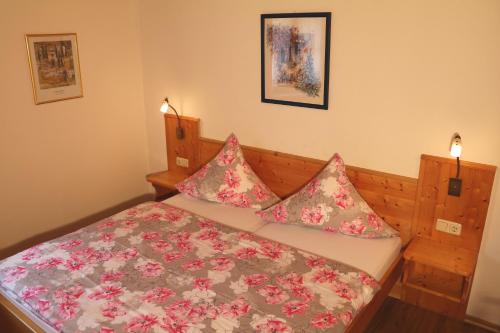 a small bedroom with a bed with pink flowers at Ferienwohnungen Vogelrast in Berchtesgaden