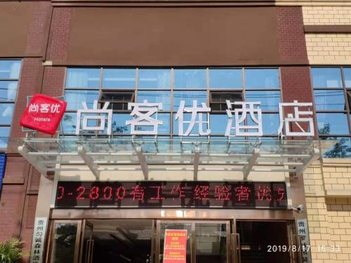 una señal en la parte delantera de un edificio en Thank Inn Chain Hotel Guizhou Qiannan Duyun Beibu Xingcheng 