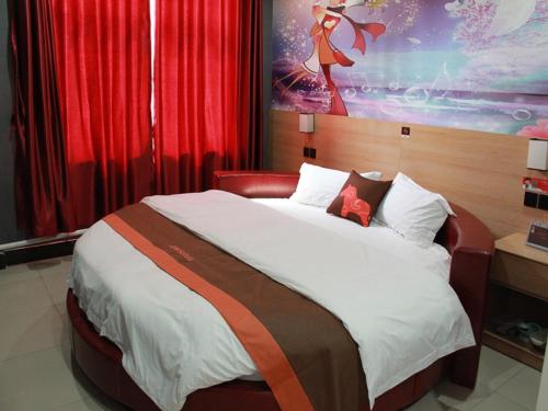 a bedroom with a large bed with red curtains at JUN Hotels Laiwu Laicheng District Changshao North Road in Laiwu