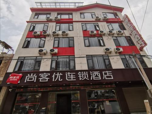 un edificio alto con escritura asiática en él en Thank Inn Chain Hotel Yunnan Dali Yunlong County Caojian Town Wanghuan Road, en Caojian