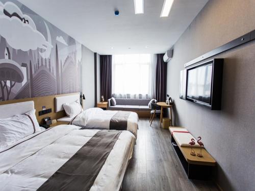 a hotel room with two beds and a flat screen tv at Thank Inn Chain Hotel Zhejiang Huzhou Deqing County Xinshi Town Huancheng West Road in Huzhou
