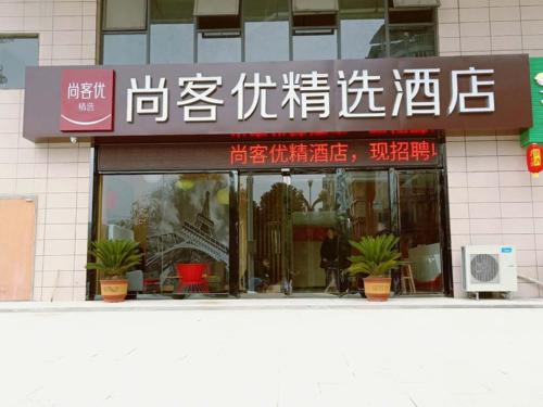 einen Laden vor einem Gebäude mit Schreiben in der Unterkunft Thank Inn Plus Hotel Guizhou Zunyi Suiyang County Shixiang Avenue in Zunyi