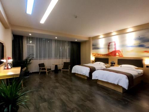 a hotel room with two beds and a table at Thank Inn Plus Hotel Shanxi Shuozhou Shuocheng District Zhangliao South Road in Shuozhou