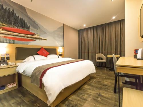 um quarto de hotel com uma cama grande e uma secretária em Thank Inn Chain Hotel Guangdong Yunfu Xinxing County Times Square Store em Yunfu
