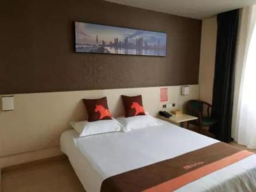 ein Schlafzimmer mit einem großen weißen Bett mit roten Kissen in der Unterkunft JUN Hotels Jiangsu Suzhou Kunshan Lujia Town Tongjin Road in Kunshan