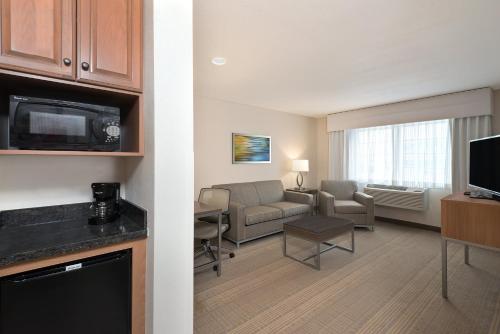 a hotel room with a living room with a couch and a table at Holiday Inn Express Hotel & Suites Fraser Winter Park Area by IHG in Fraser