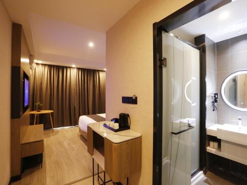 a hotel room with a bathroom with a sink and a shower at Up and In Kashgar Xiyu Avenue Food Street in Kashgar