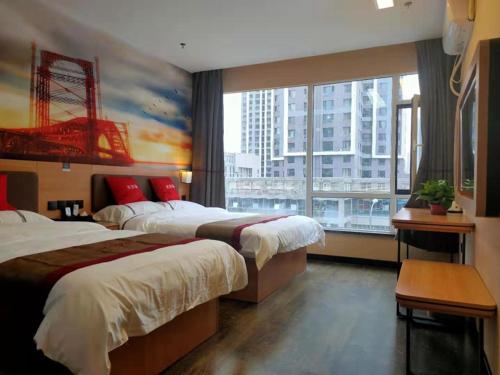 a hotel room with two beds and a large window at Thank Inn Chain Hotel Lanzhou Chengguan District Jiaojiawan Subway Station in Lanzhou