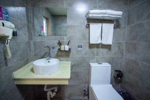 a bathroom with a sink and a toilet at JUN Hotels Hebei Hengshui Shenzhou Bus Station in Hengshui
