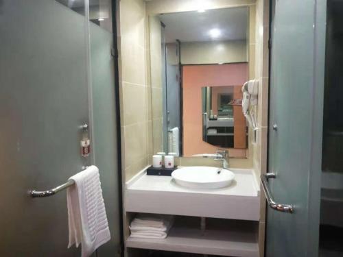 a bathroom with a sink and a mirror at Thank Inn Chain Hotel Anhui Bozhou Qiaocheng District Jian'an Road Wanfu Store in Bozhou