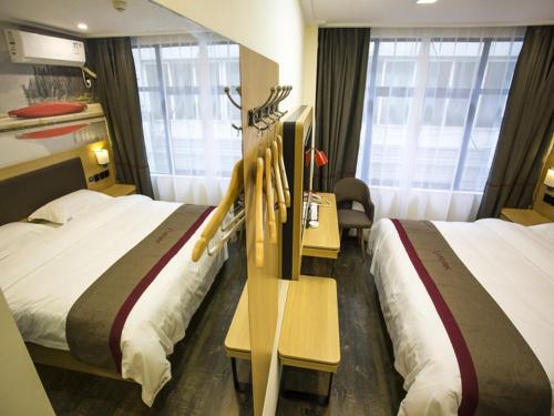 una camera d'albergo con due letti e divisori in legno di Thank Inn Plus Hotel Yichang Free Trade Zone Development Avenue a Yichang