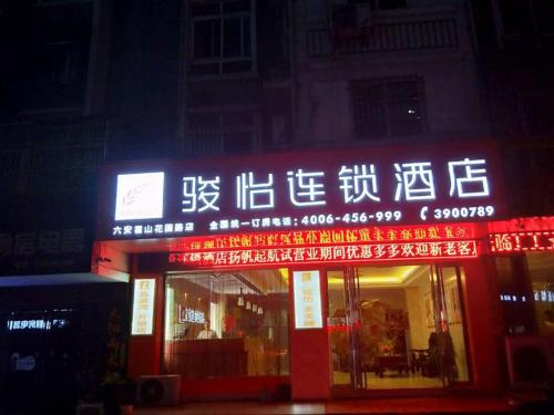 una tienda con señales encendidas en la parte delantera. en JUN Hotels Lu'an Huoshan County Huayuan Road, en Lu'an