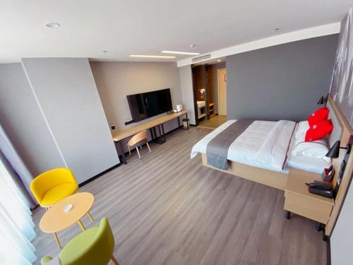邯鄲市にあるThank Inn Chain Hotel Hebei Handan Ci County Xinshijiの大型ベッドとテレビが備わるホテルルームです。