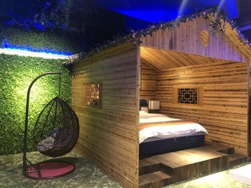 a room with a bed and a swing at JUN Hotels Jiangnan Nanchang Nanchang County Xiaolan Industrial Park in Nanchang