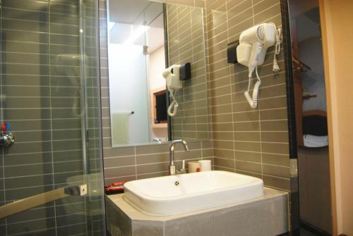 a bathroom with a sink and a mirror and a shower at Thank Inn Chain Hotel Hebei Baoding Wangdu County Bus Station in Baoding